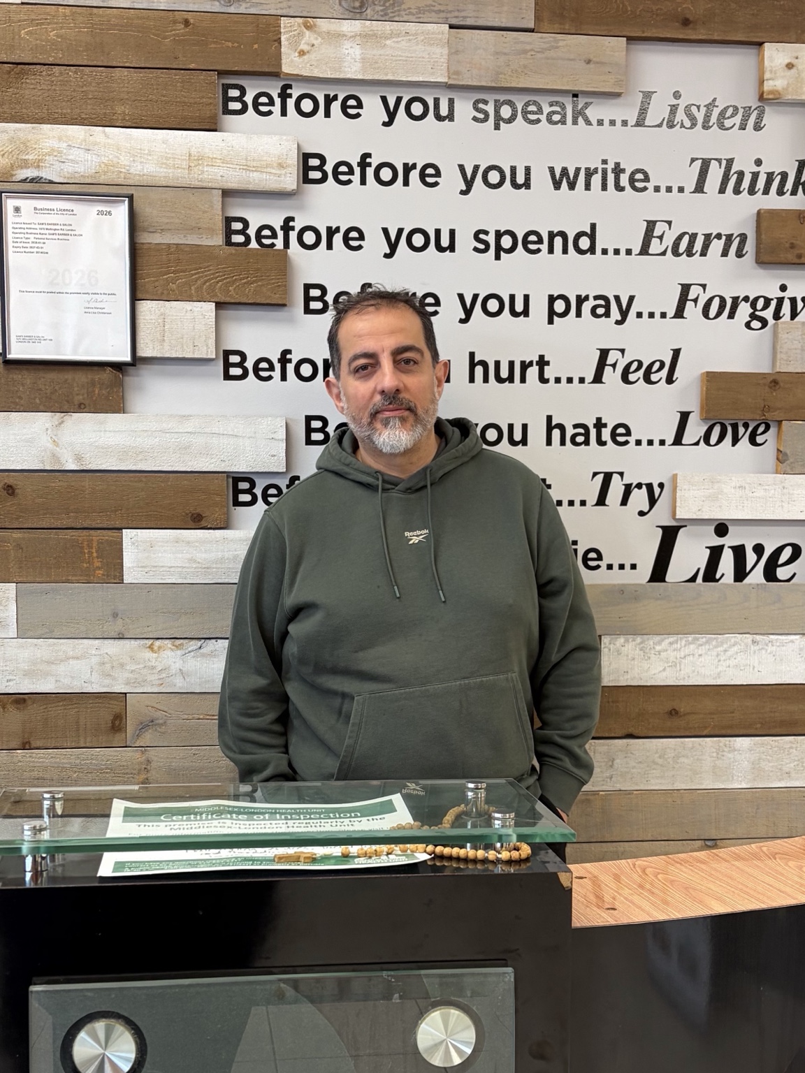 Sam, barber with 15+ years of experience, professional portrait in barbershop